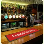 Promotional display for Coastal Coasters featuring branded print products for hospitality and retail marketing.