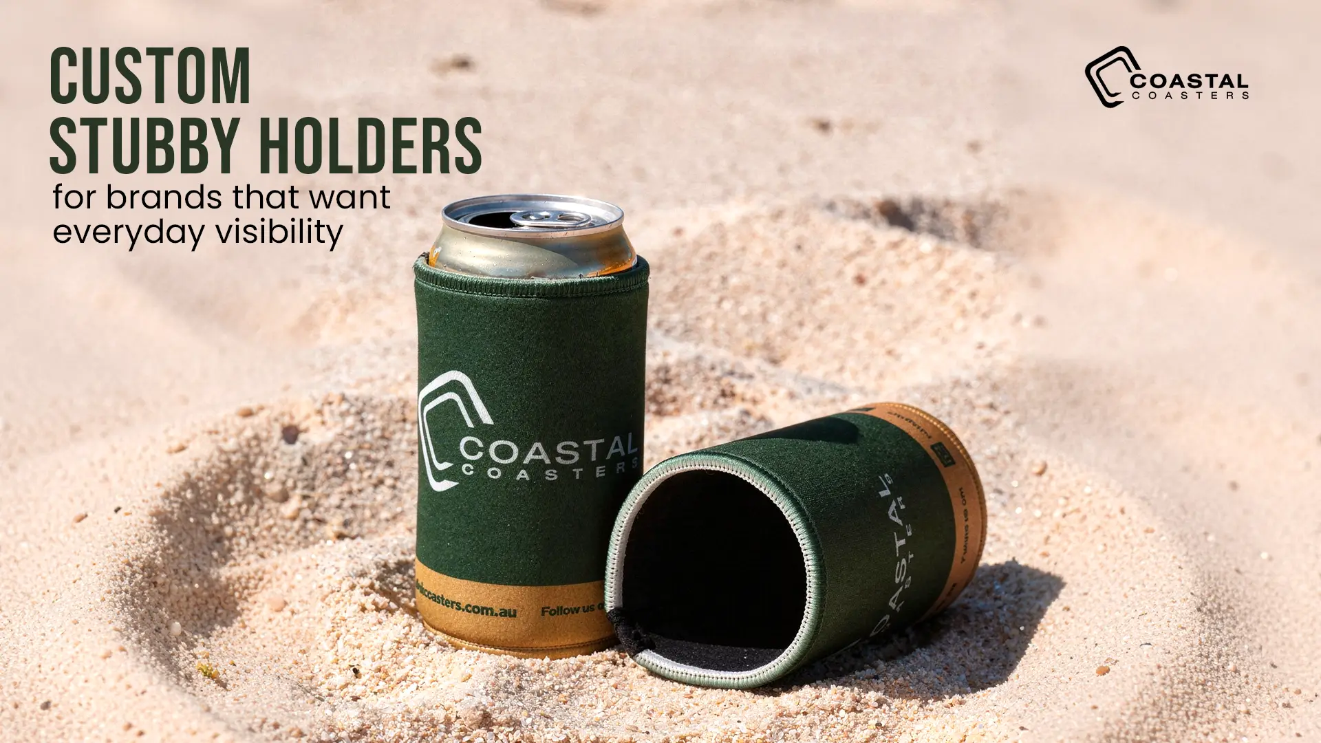 Custom Coastal Coasters stubby holders displayed on sand with branded can cooler